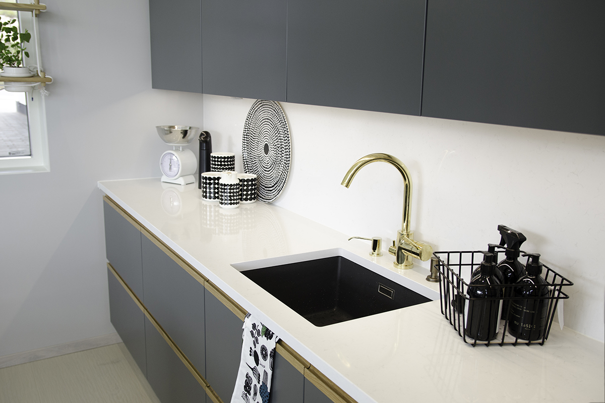 White-grey kitchen with a golden faucet